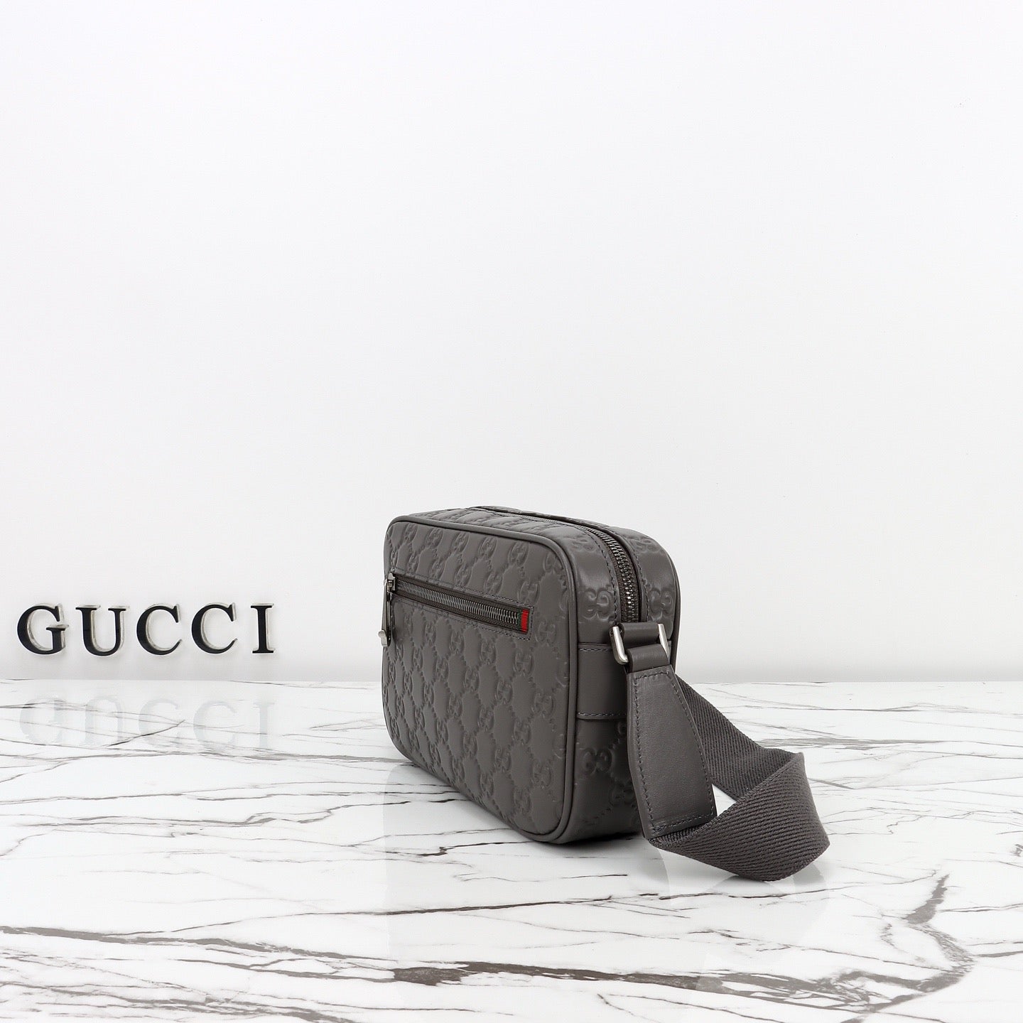Gucci Sac Bandoulière Gucci GG Embossed Disponible en Beige ou Noir avec Zip Frontal Web Stripe