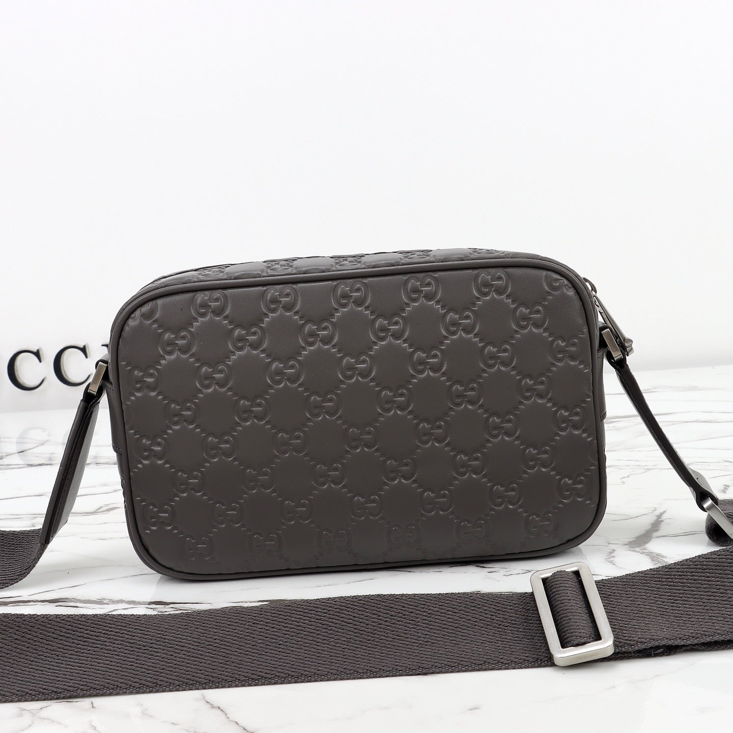 Gucci Sac Bandoulière Gucci GG Embossed Disponible en Beige ou Noir avec Zip Frontal Web Stripe