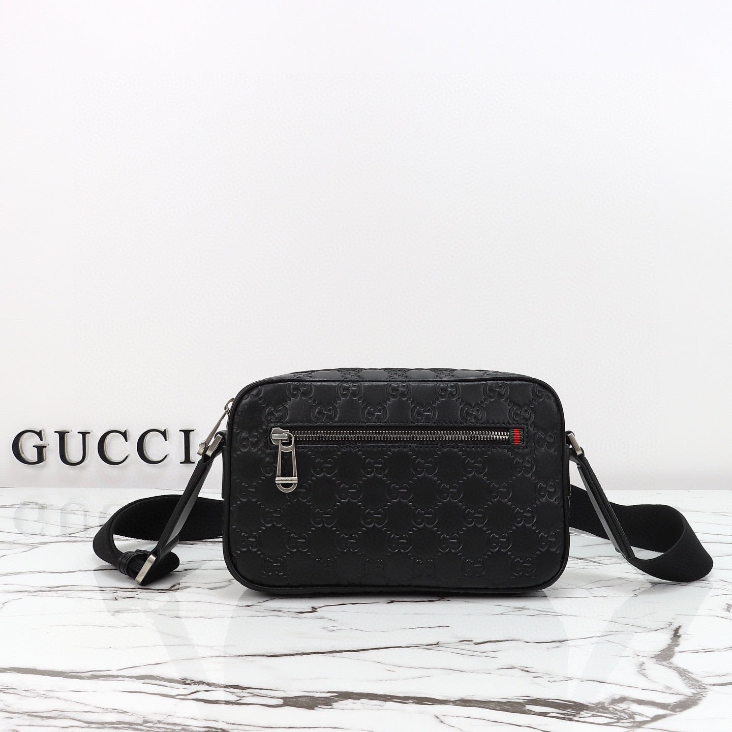 Gucci Sac Bandoulière Gucci GG Embossed Disponible en Beige ou Noir avec Zip Frontal Web Stripe
