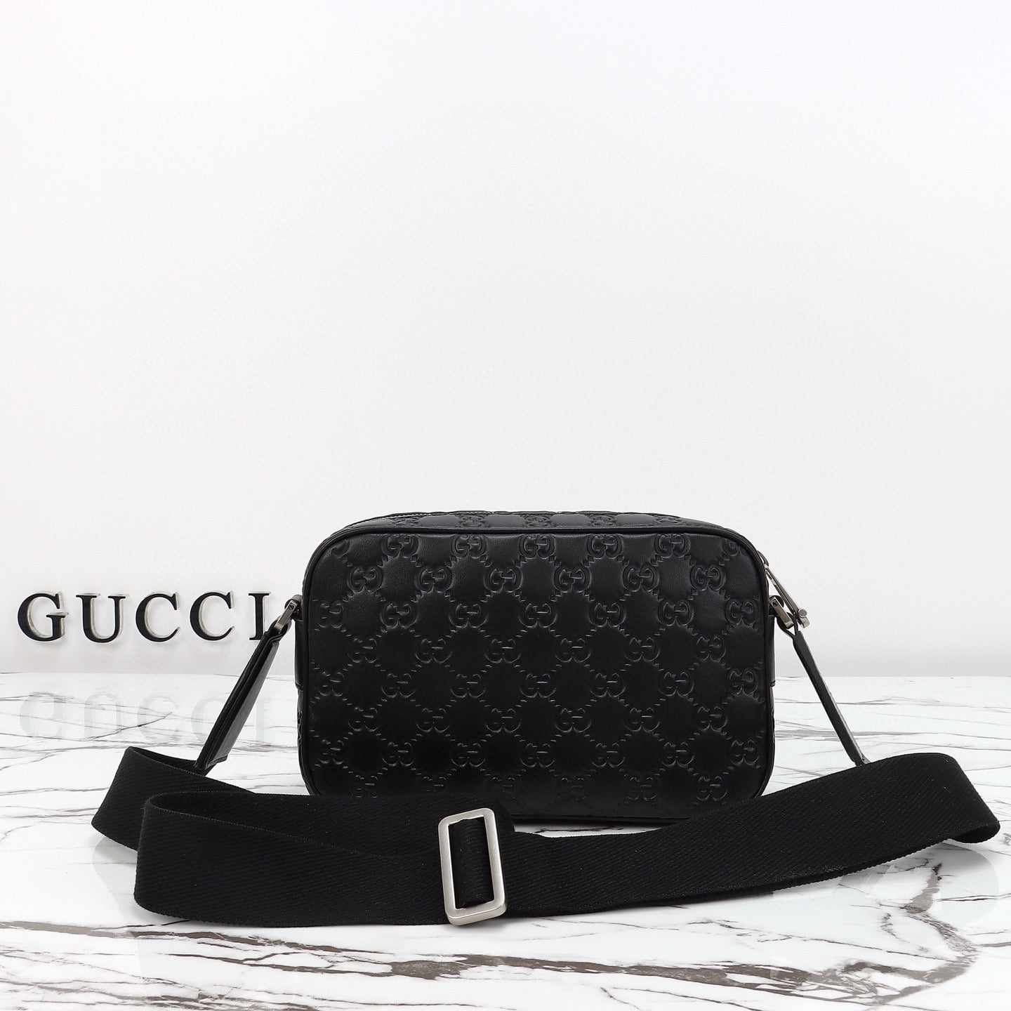 Gucci Sac Bandoulière Gucci GG Embossed Disponible en Beige ou Noir avec Zip Frontal Web Stripe
