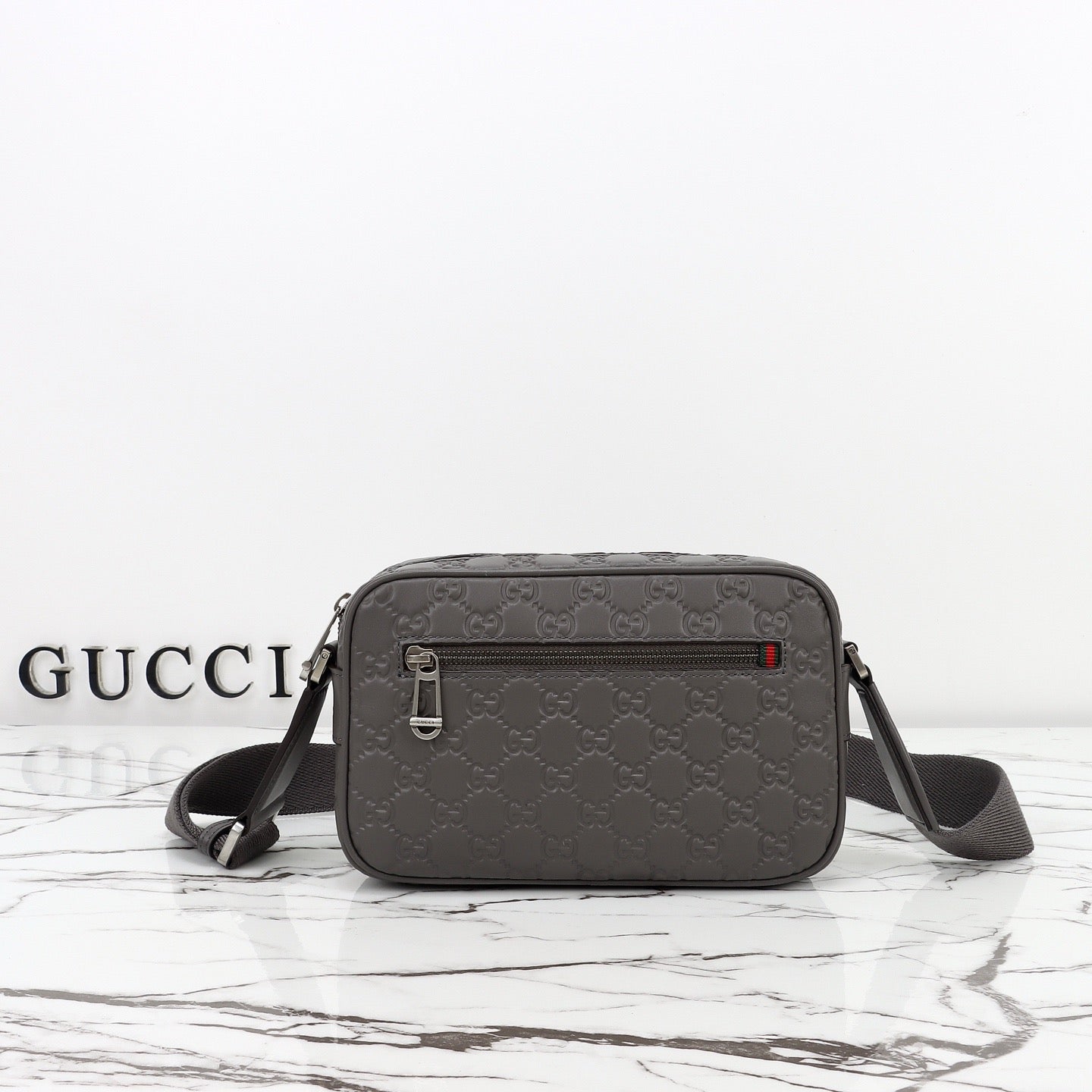 Gucci Sac Bandoulière Gucci GG Embossed Disponible en Beige ou Noir avec Zip Frontal Web Stripe